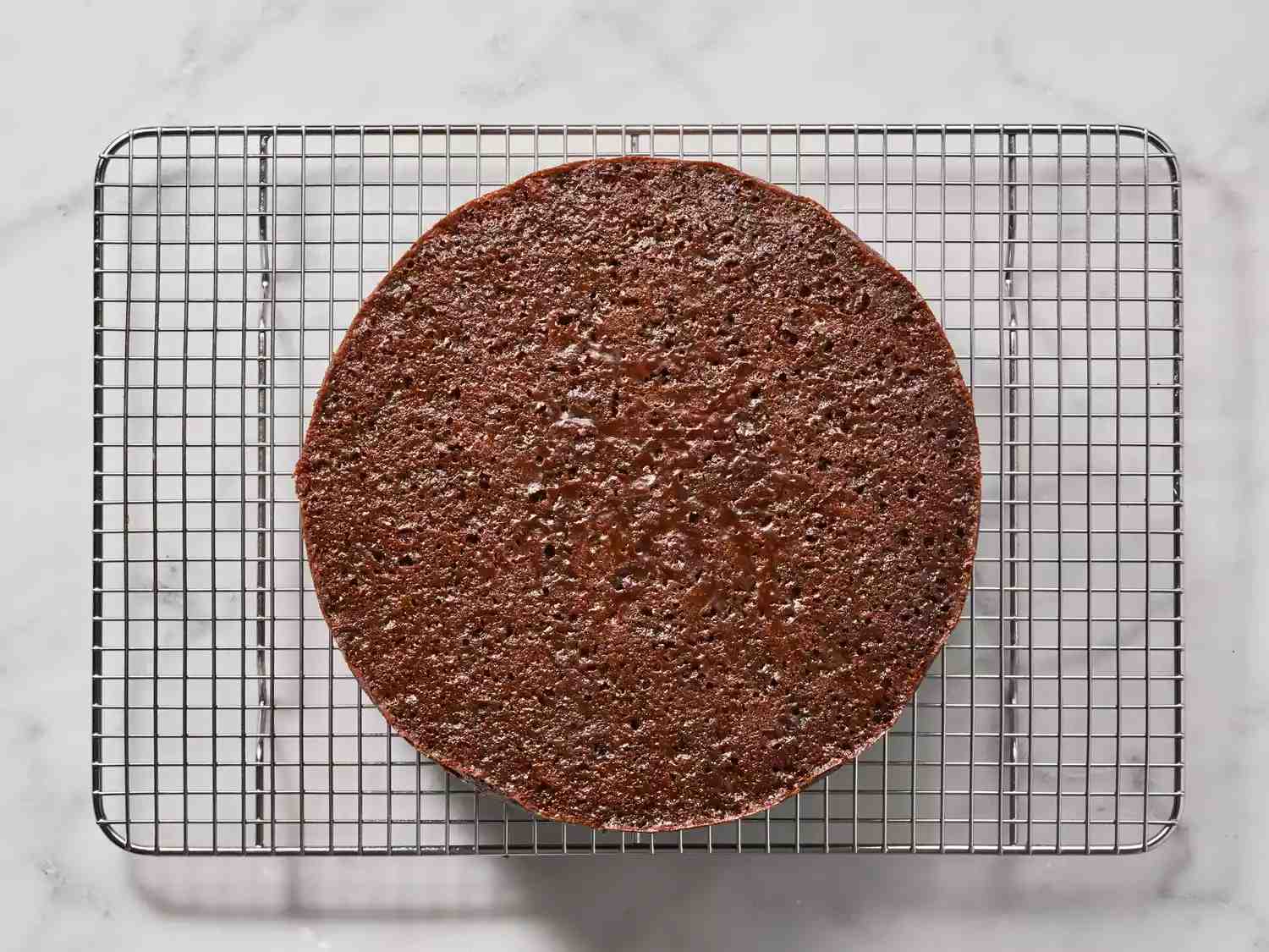 کیک کریسمس در حال خنک شدن روی توری سیمی، برای طرز تهیه کیک کریسمس. 